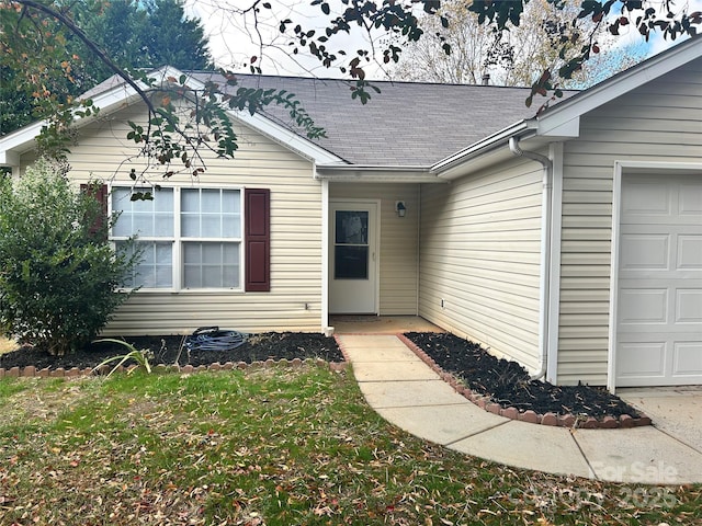 entrance to property with a yard and a garage