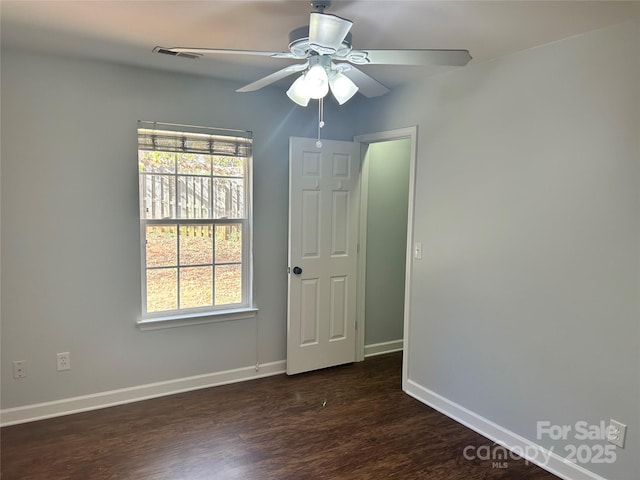 unfurnished room with dark wood-type flooring and ceiling fan