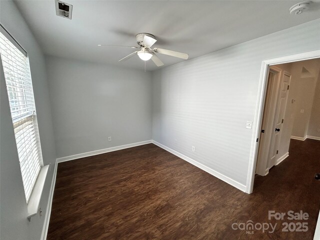 empty room featuring ceiling fan and dark hardwood / wood-style flooring