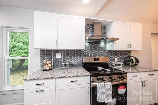 kitchen with stainless steel range, wall chimney exhaust hood, white cabinetry, and tasteful backsplash