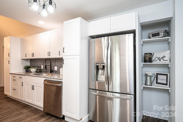 kitchen featuring sink, white cabinetry, stainless steel appliances, light stone counters, and dark hardwood / wood-style floors