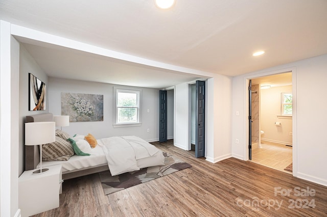 bedroom featuring ensuite bathroom and wood-type flooring