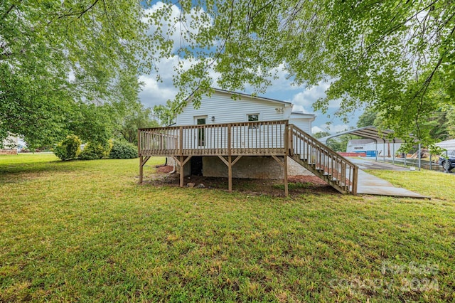 rear view of house with a yard, a carport, and a wooden deck