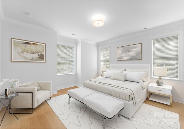 bedroom featuring light hardwood / wood-style floors and crown molding