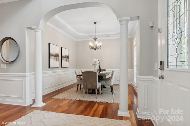 dining room with ornamental molding, a chandelier, hardwood / wood-style flooring, and a tray ceiling