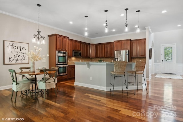 kitchen featuring a large island, dark wood-type flooring, hanging light fixtures, and stainless steel appliances