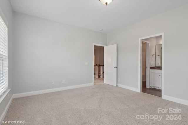 unfurnished bedroom featuring carpet floors and ensuite bath