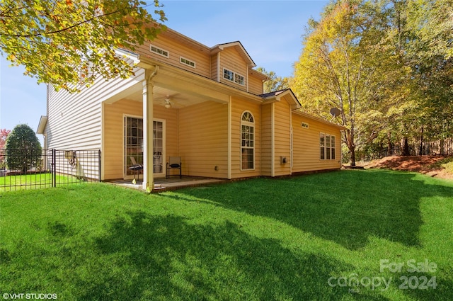 rear view of house featuring a patio, a lawn, and ceiling fan