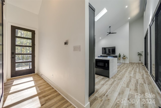 entrance foyer featuring light hardwood / wood-style flooring, high vaulted ceiling, and ceiling fan