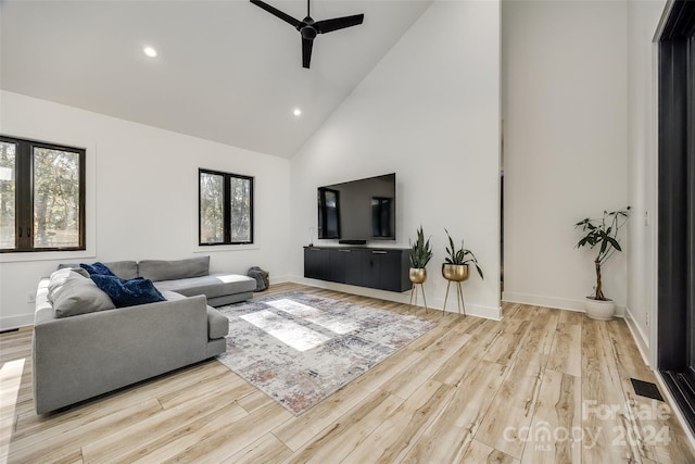 living room featuring ceiling fan, a healthy amount of sunlight, and light wood-type flooring