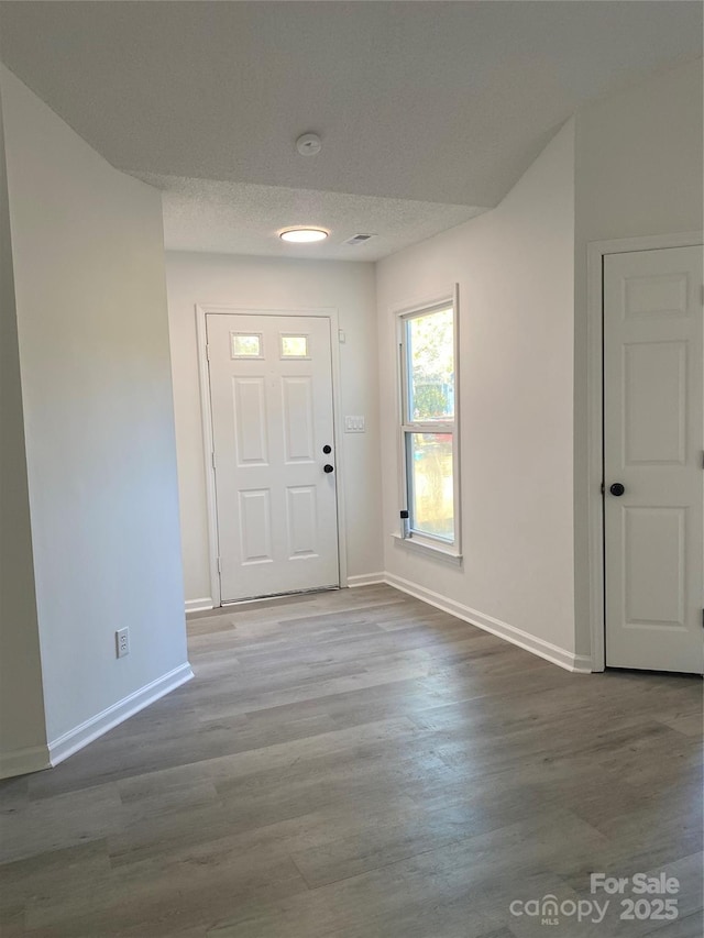 foyer entrance featuring hardwood / wood-style flooring and a textured ceiling