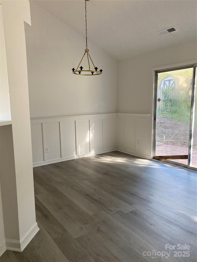 unfurnished dining area featuring dark hardwood / wood-style floors and a notable chandelier