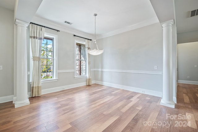 unfurnished dining area featuring light hardwood / wood-style floors, crown molding, and a chandelier