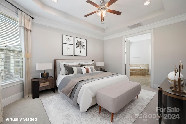 carpeted bedroom with ornamental molding, ceiling fan, ensuite bathroom, and a raised ceiling