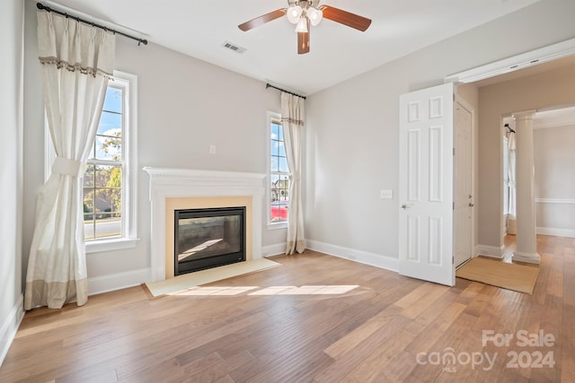 unfurnished living room featuring light hardwood / wood-style floors and decorative columns