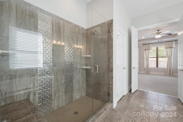 bathroom with a shower with door, tile patterned flooring, and ceiling fan