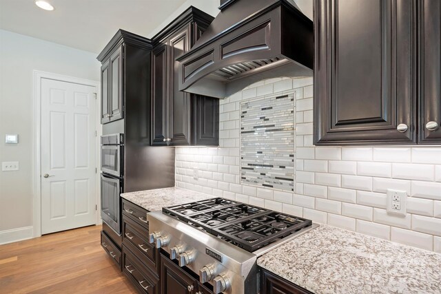 kitchen with light hardwood / wood-style floors, stainless steel gas stovetop, and tasteful backsplash