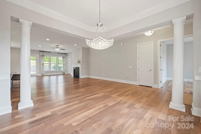 unfurnished living room featuring ornamental molding, light hardwood / wood-style flooring, ornate columns, and ceiling fan with notable chandelier