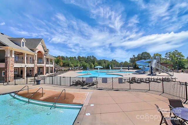 view of pool featuring a patio area and a water slide