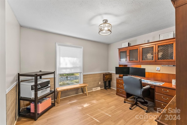 office space featuring light hardwood / wood-style flooring and a textured ceiling