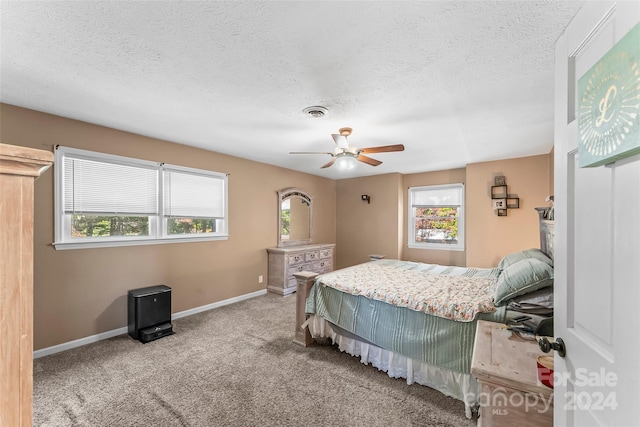 bedroom with a textured ceiling, carpet floors, and ceiling fan