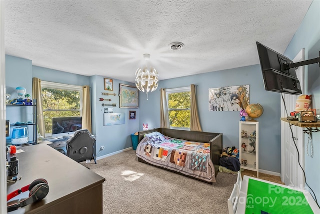 bedroom featuring a textured ceiling, carpet flooring, and an inviting chandelier