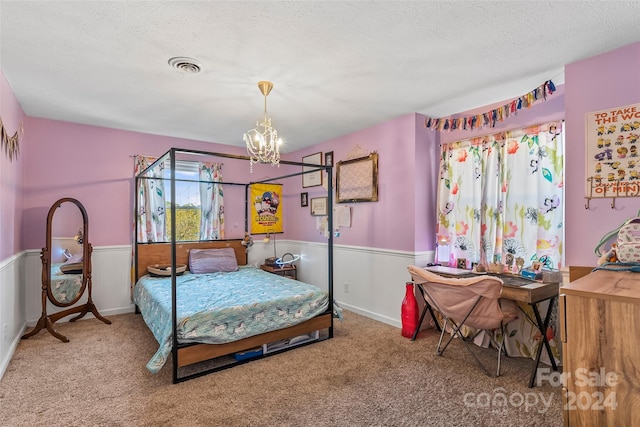 bedroom with a textured ceiling, a chandelier, and carpet