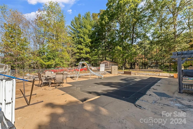 view of swimming pool featuring a storage unit and a patio