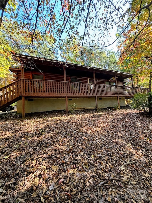 rear view of house featuring a wooden deck