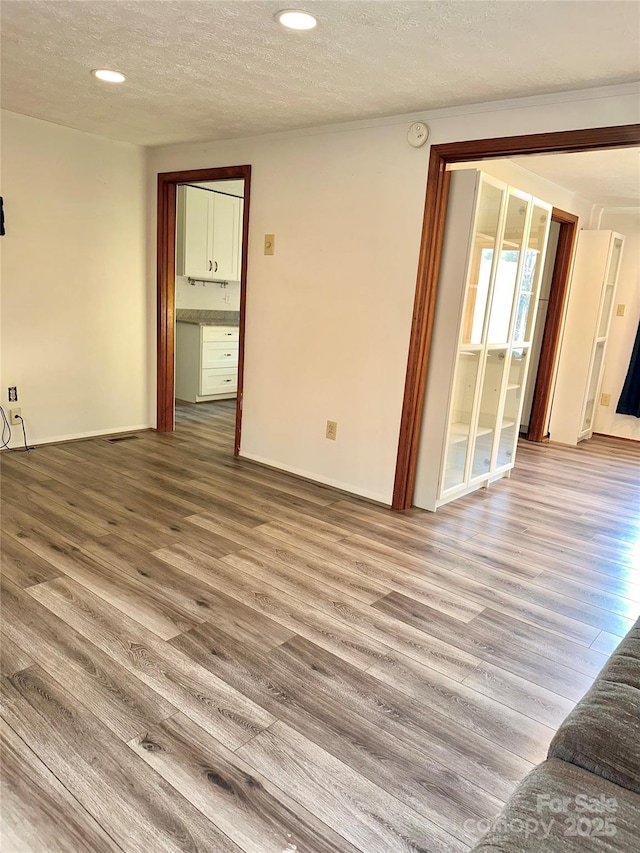 spare room featuring hardwood / wood-style flooring and a textured ceiling