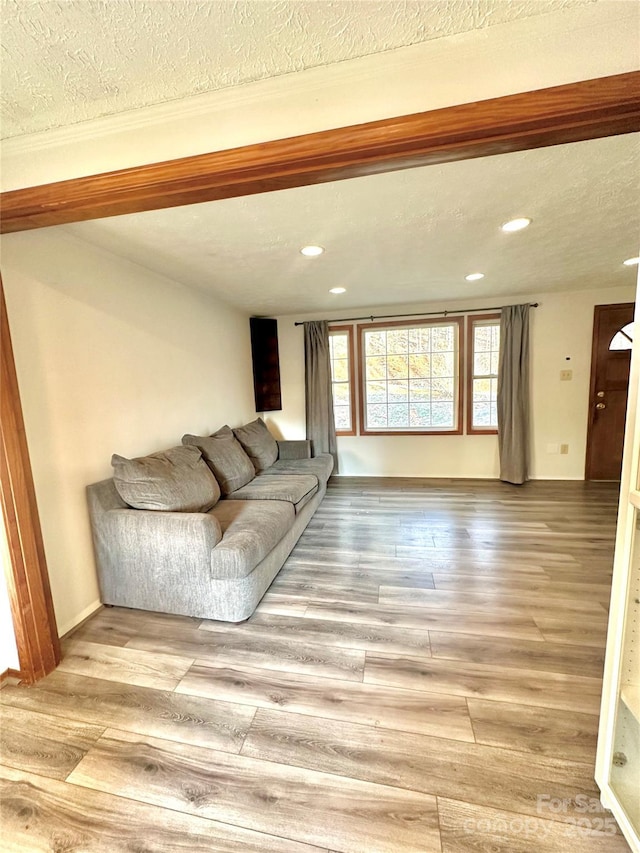 unfurnished living room featuring a textured ceiling and light hardwood / wood-style flooring