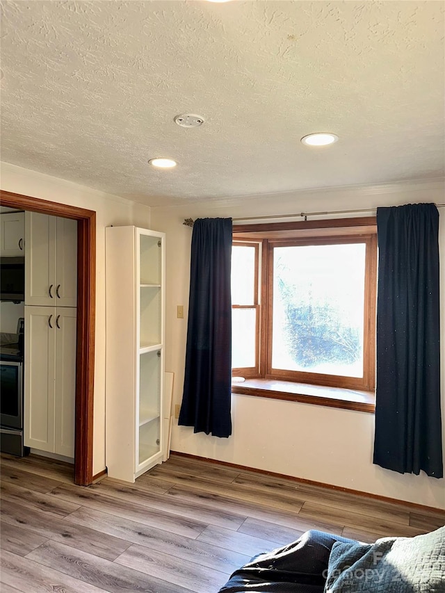 unfurnished bedroom featuring light hardwood / wood-style floors, a closet, and a textured ceiling