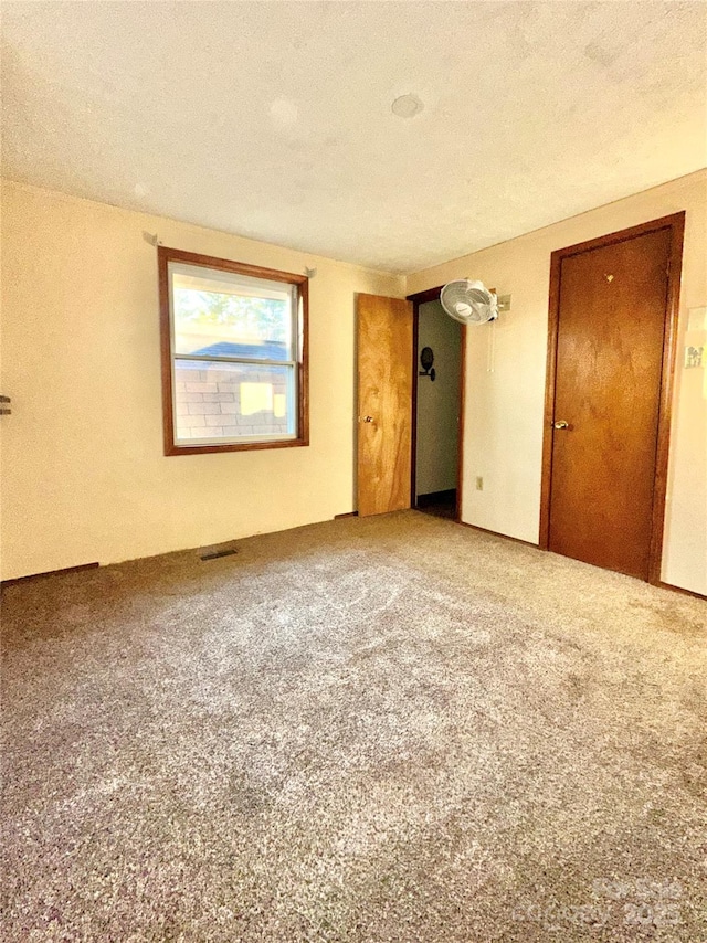 unfurnished bedroom with carpet flooring and a textured ceiling