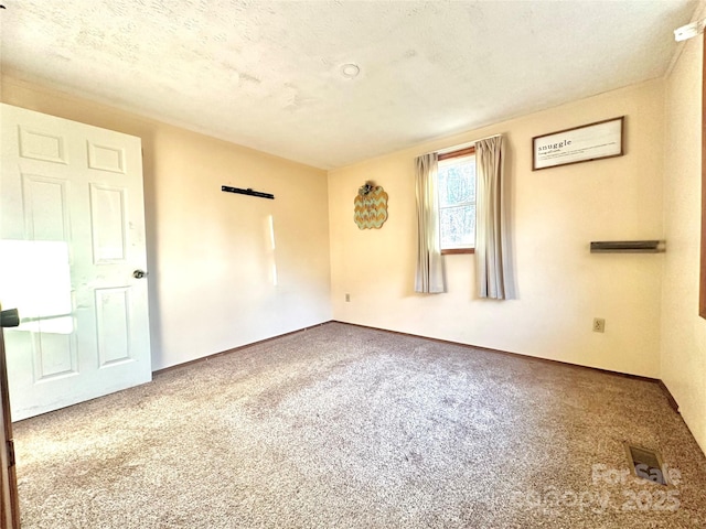 carpeted spare room with a textured ceiling