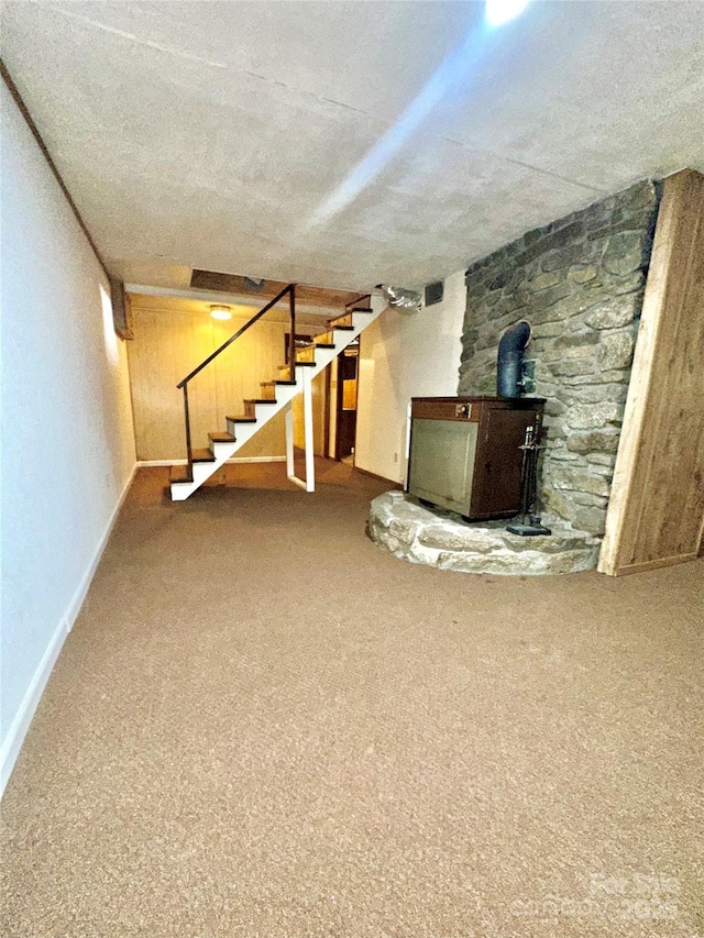 basement with carpet and a wood stove