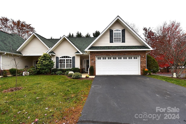 view of front of home with a front yard and a garage