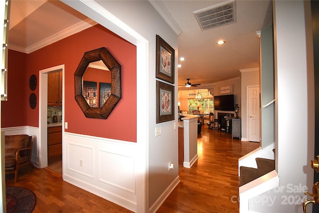 hall with ornamental molding and dark wood-type flooring