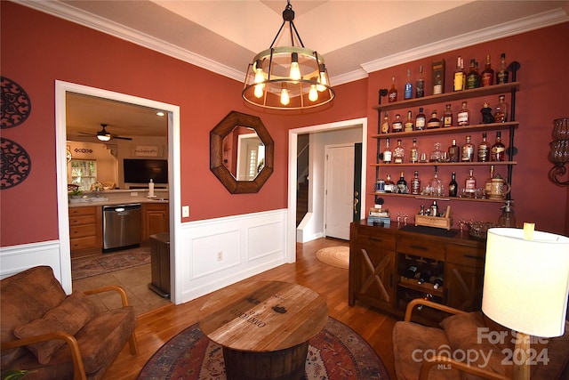 bar with wood-type flooring, ceiling fan with notable chandelier, decorative light fixtures, stainless steel dishwasher, and ornamental molding