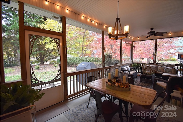 sunroom / solarium with ceiling fan with notable chandelier