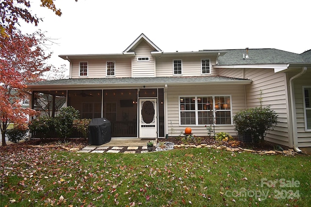 view of front of house with a sunroom and a front lawn