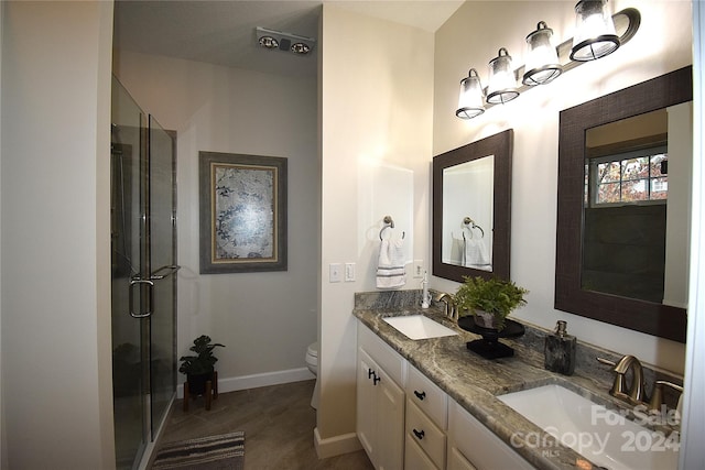 bathroom featuring vanity, a shower with shower door, and toilet