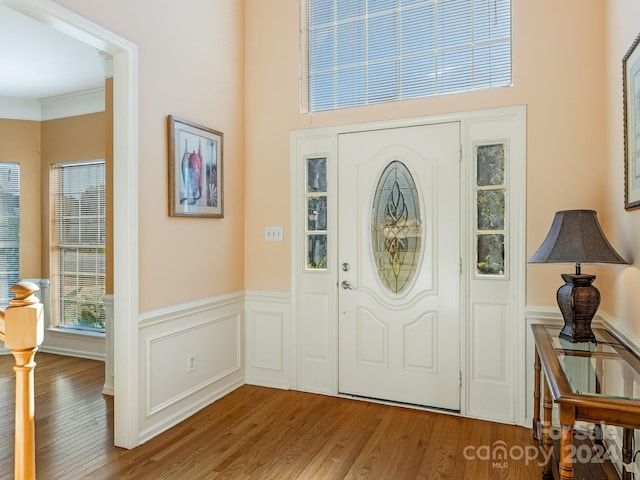 entryway featuring hardwood / wood-style floors and crown molding