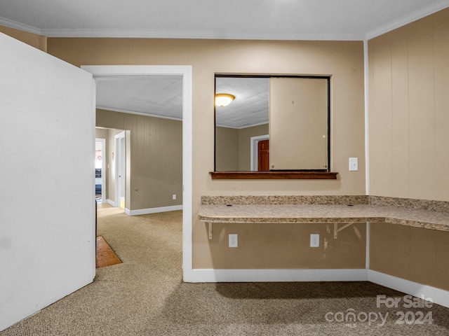 hall with carpet, ornamental molding, and wooden walls