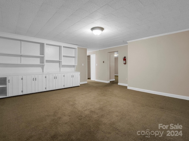 unfurnished living room featuring ornamental molding, a textured ceiling, built in shelves, and carpet flooring