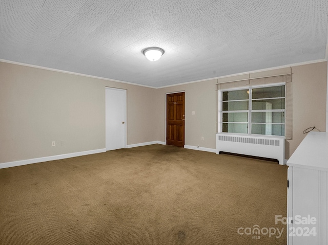 unfurnished room with carpet flooring, radiator heating unit, crown molding, and baseboards