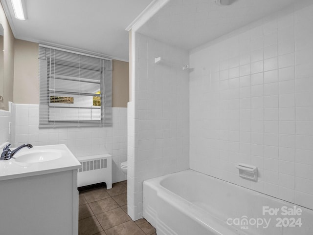 full bathroom with tile patterned floors, toilet, vanity, tile walls, and radiator heating unit