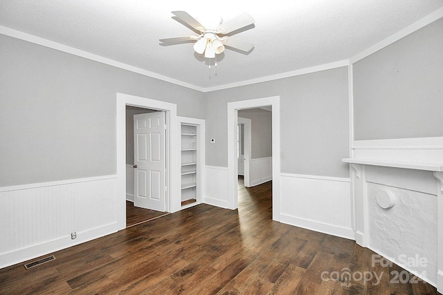 unfurnished living room featuring ceiling fan, crown molding, a textured ceiling, and dark hardwood / wood-style flooring