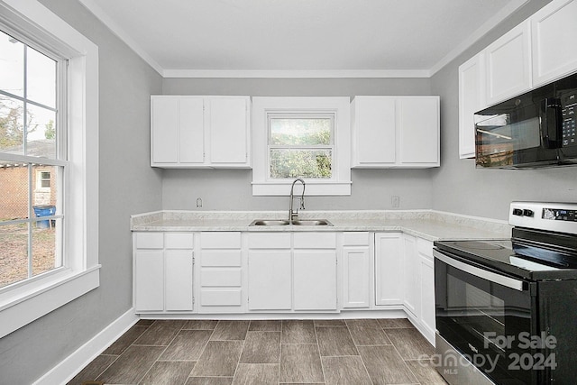 kitchen featuring sink, stainless steel range with electric cooktop, hardwood / wood-style floors, white cabinets, and ornamental molding