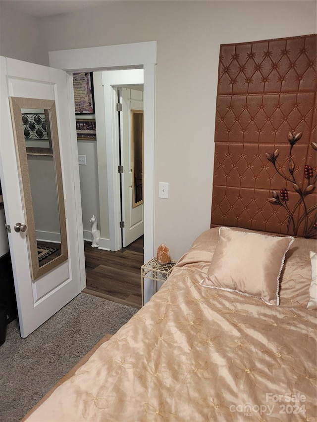 bedroom with dark hardwood / wood-style floors and a closet