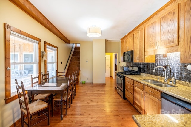 kitchen featuring decorative backsplash, light hardwood / wood-style flooring, stainless steel appliances, sink, and light stone countertops